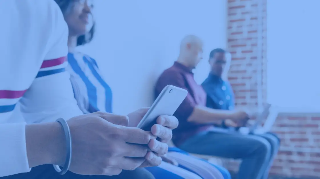 automated texting software - picture of 4 people sitting down, one person holding a phone